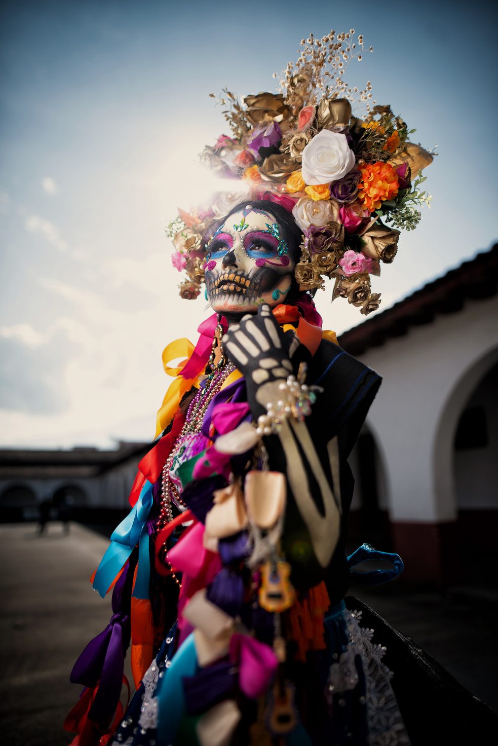 A catrina figure in colorful ribbons and flowers