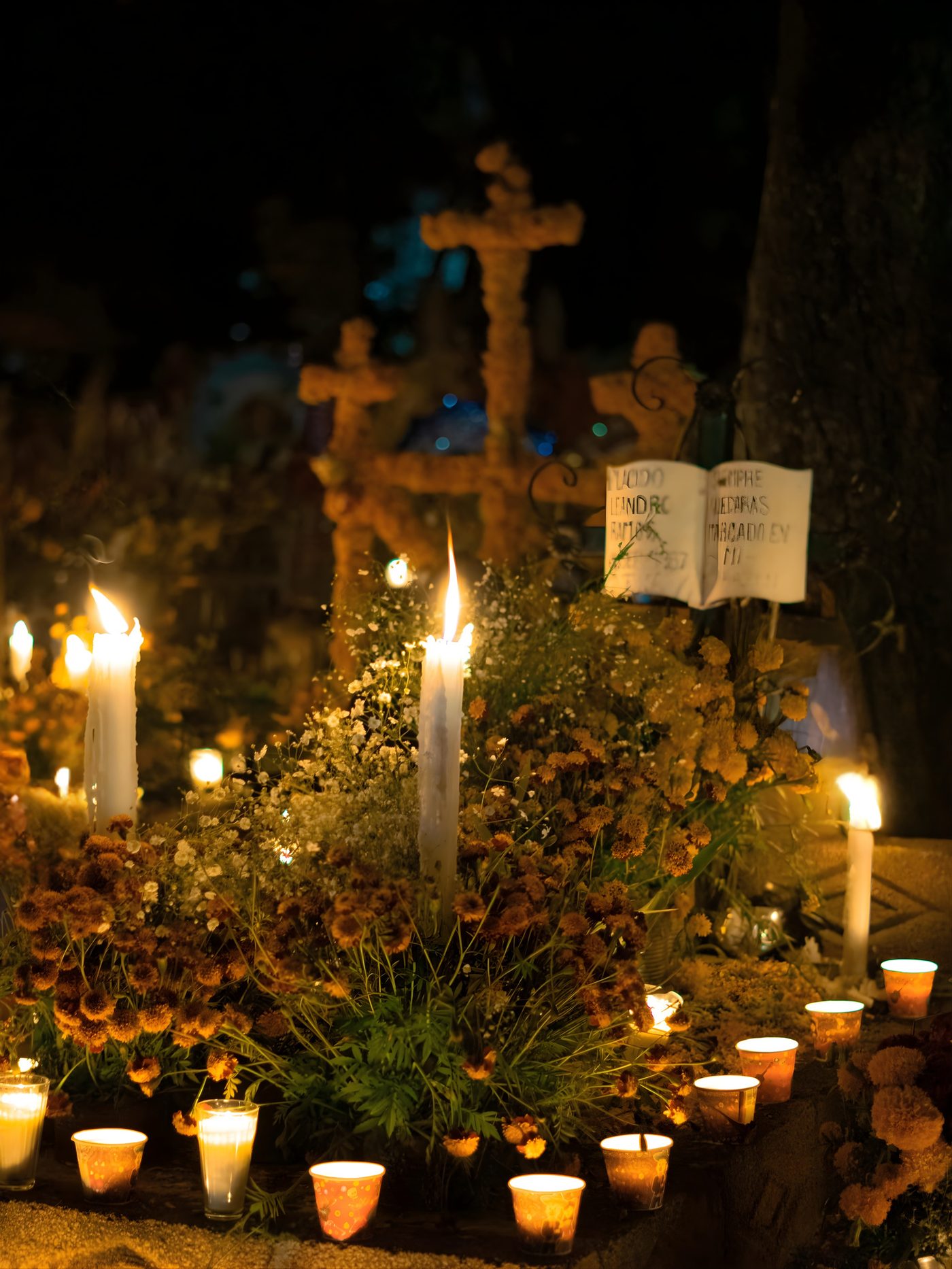 Candles and marigolds at a Day of the Dead altar at night